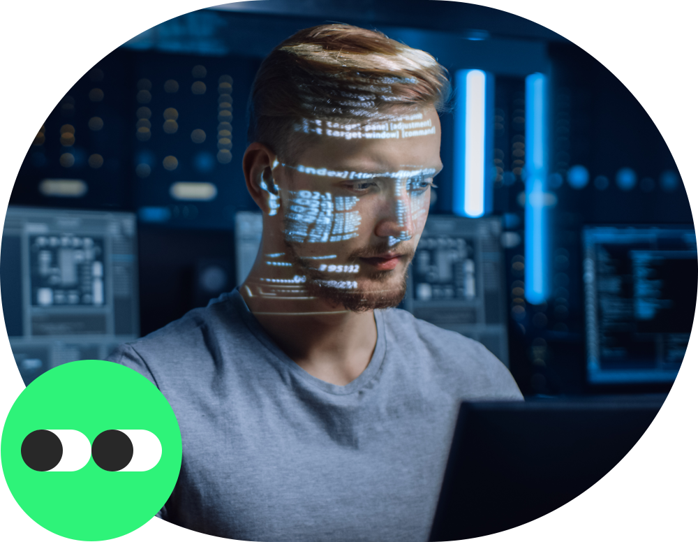Programátor sedí za monitorem v místnosti plné počítačů
