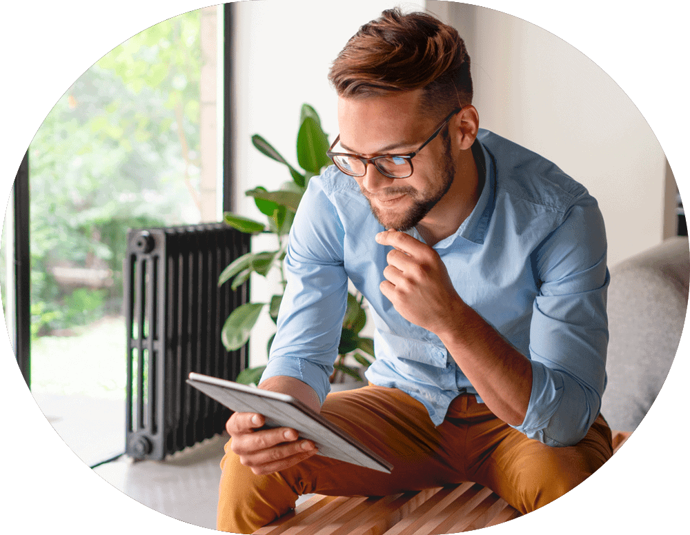 Muž sedící v moderním interiéru, který sleduje obsah na tabletu – řiďte efektivně své projekty díky výkonnému webhostingu, VPS nebo dedikovanému serveru.